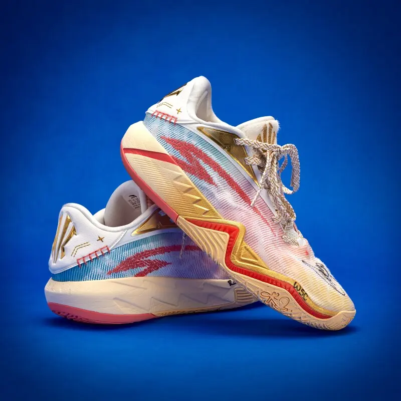 Colorful athletic sneakers with pink, gold, and teal accents stacked against a blue background (product shot).️