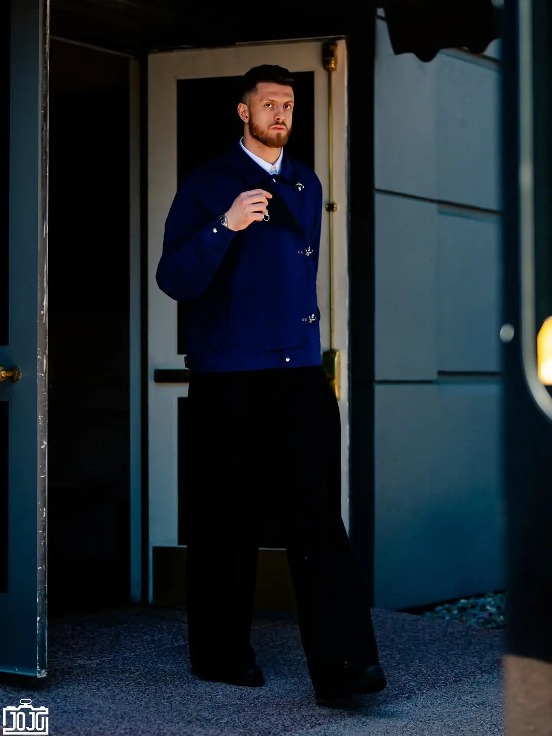 Isaiah hartenstein - the game Man in a navy jacket stands in a doorway, adjusting sunglasses and looking at the camera.