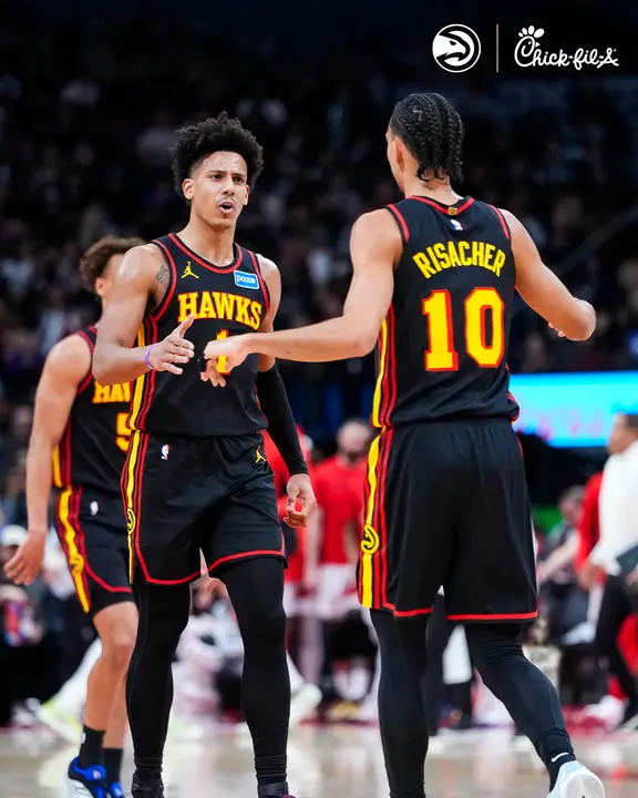 Saveclipapp_640384013_18574032976009226_1888558634154255493_n - the game Two Atlanta Hawks players in black uniforms high-five on a basketball court during a game.