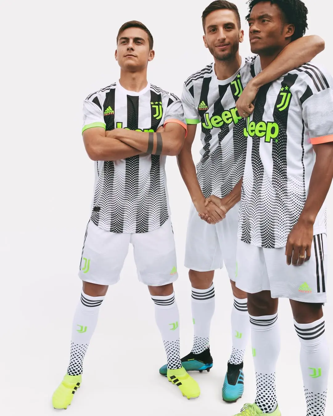 Three Juventus soccer players wearing black-and-white striped jerseys, arms around shoulders, posing together.