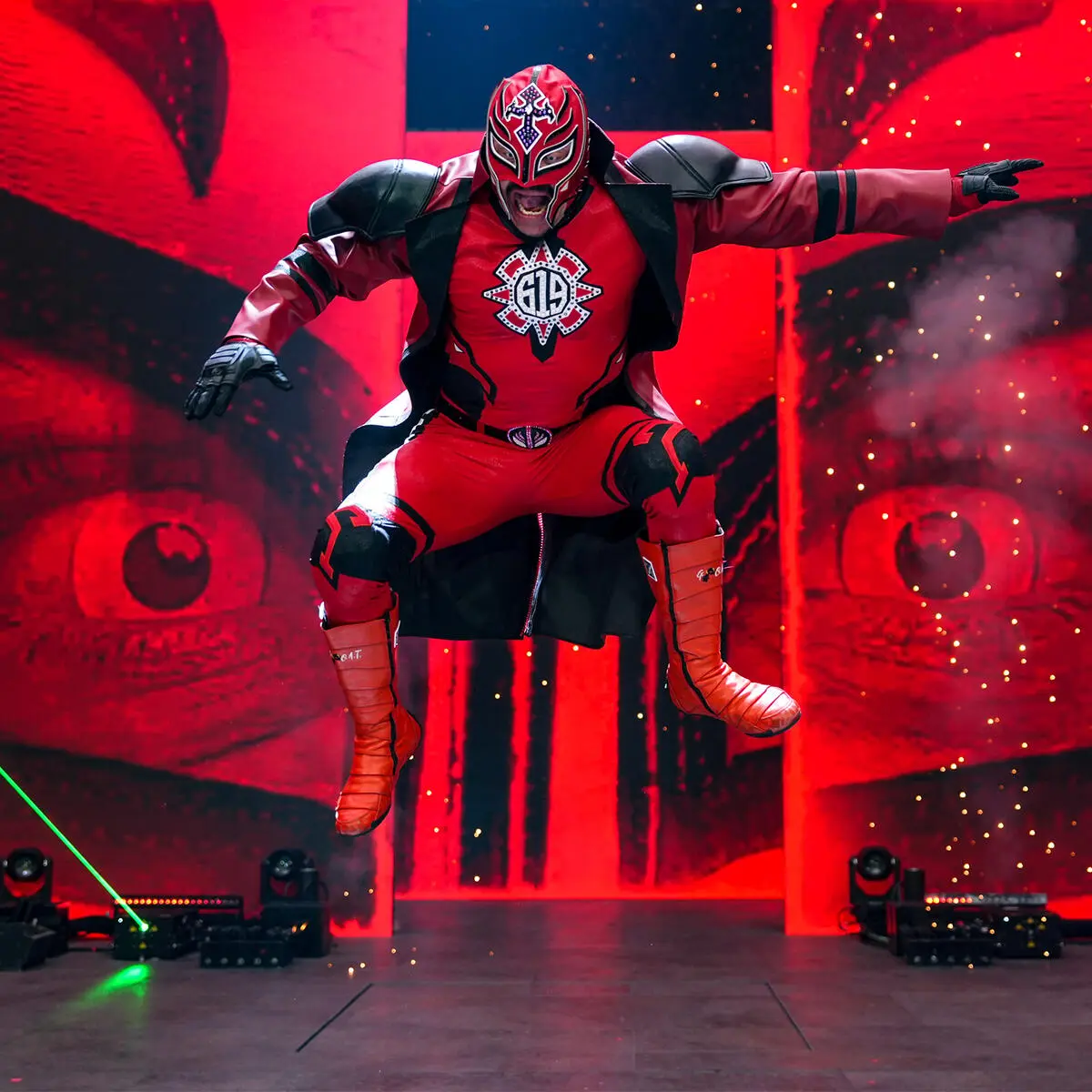 Rey mysterio - the game Masked luchador in a red-and-black suit leaps midair on a red-lit stage, dramatic entrance scene