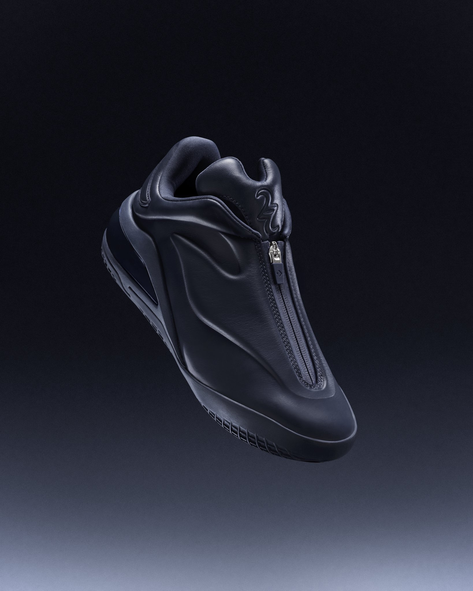 Black sleek sneaker with a vertical zipper and padded collar, floating against a dark gradient background.