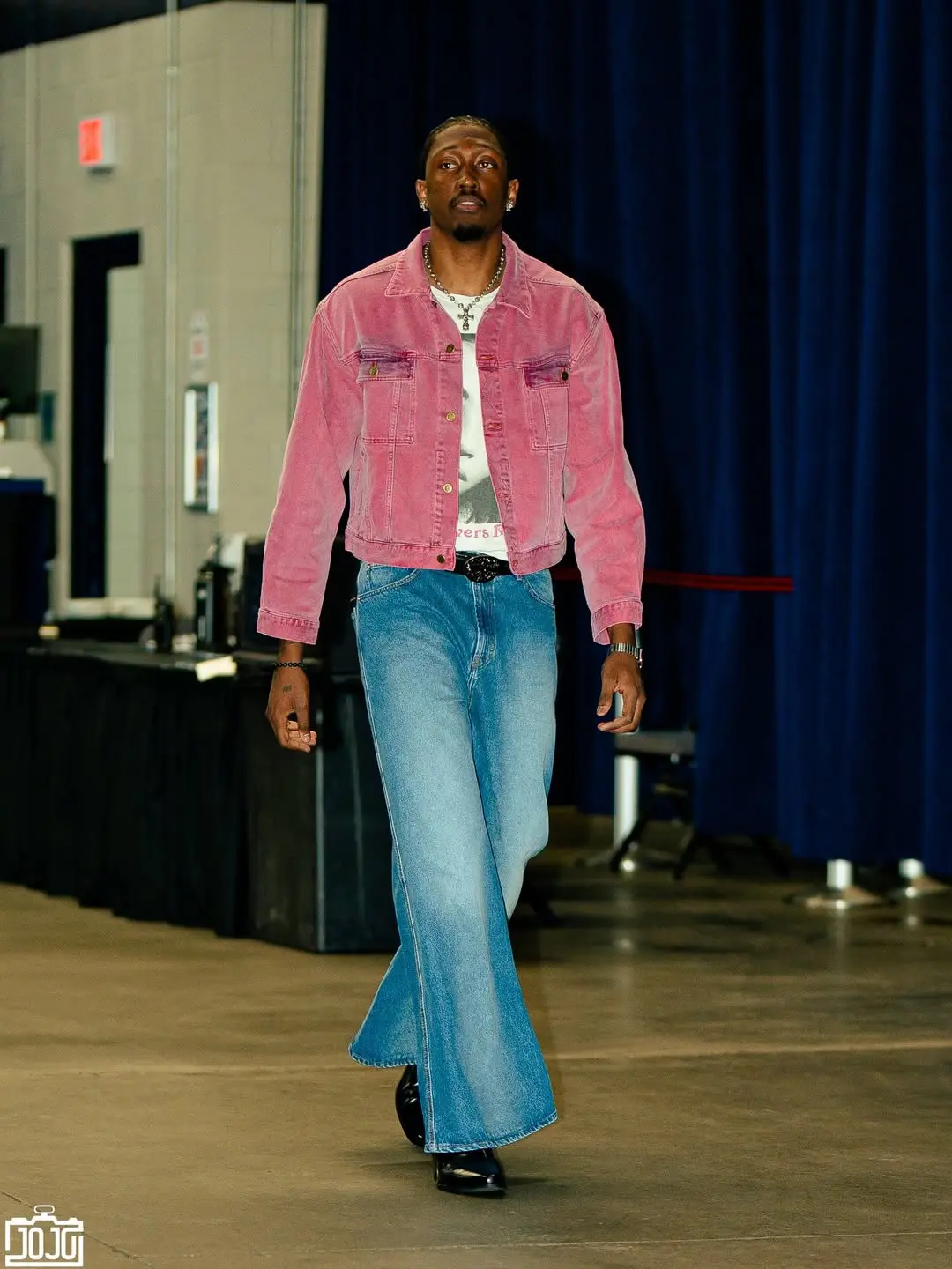 Jalen williams - the game Model walking a runway in a pink denim jacket, white shirt, and flared blue jeans with black boots and silver jewelry.