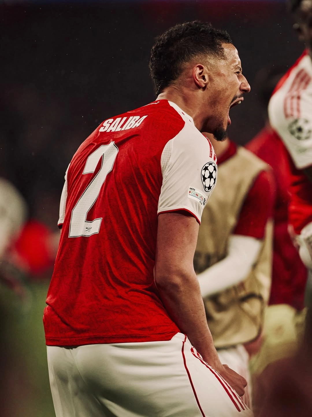 Saliba - the game Soccer player in a red jersey with number 2 on the back, shouting in celebration on the pitch.