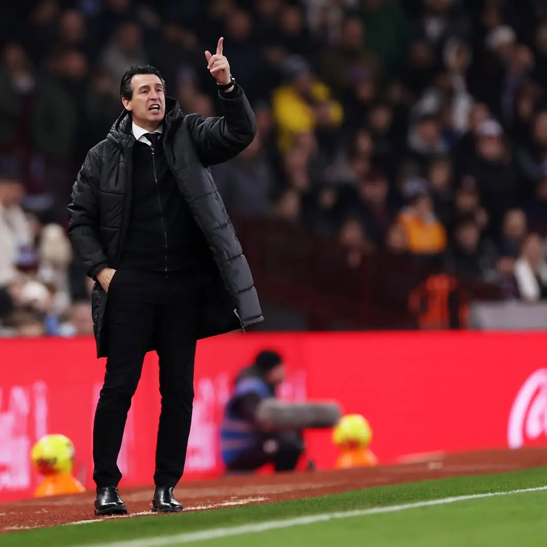 Unai emery - the game Soccer coach in a black puffer coat on the sideline, pointing and giving instructions to players.