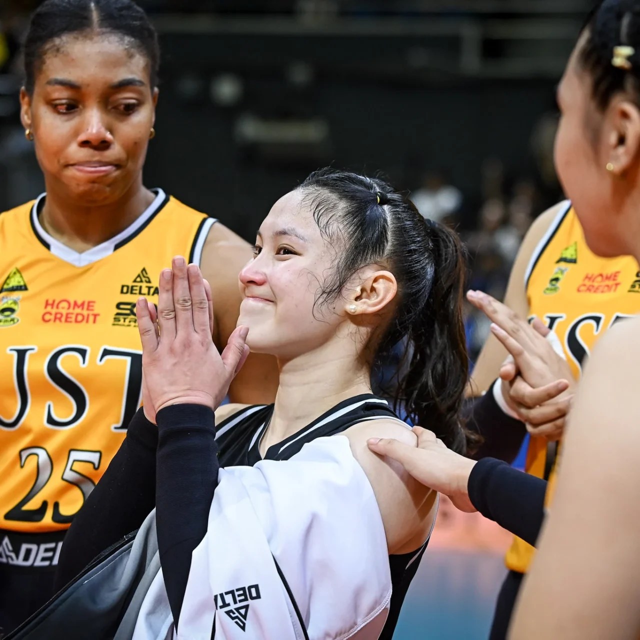 Group of female basketball players in USA uniforms sharing a high-five, smiling.