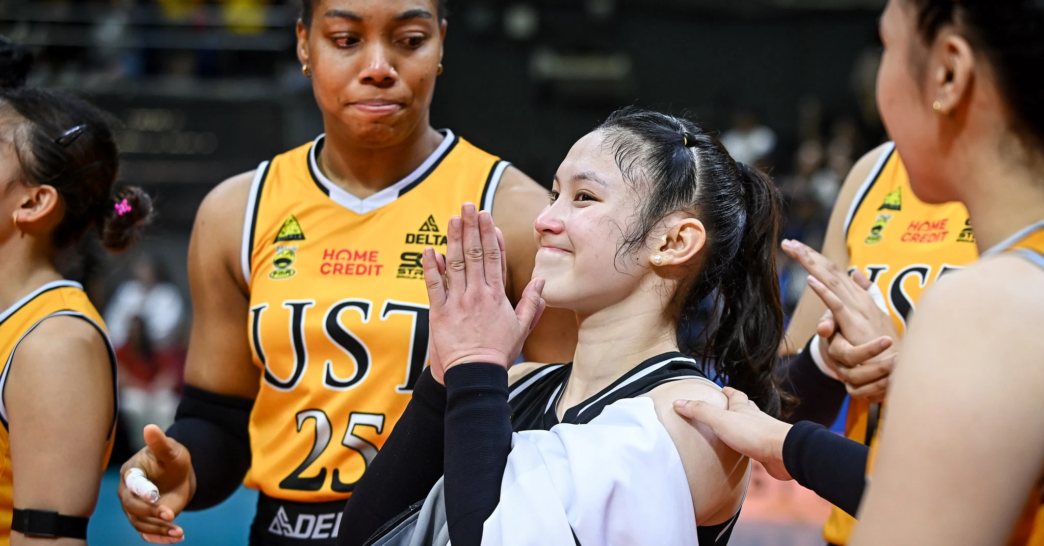 Group of female basketball players in USA uniforms sharing a high-five, smiling.